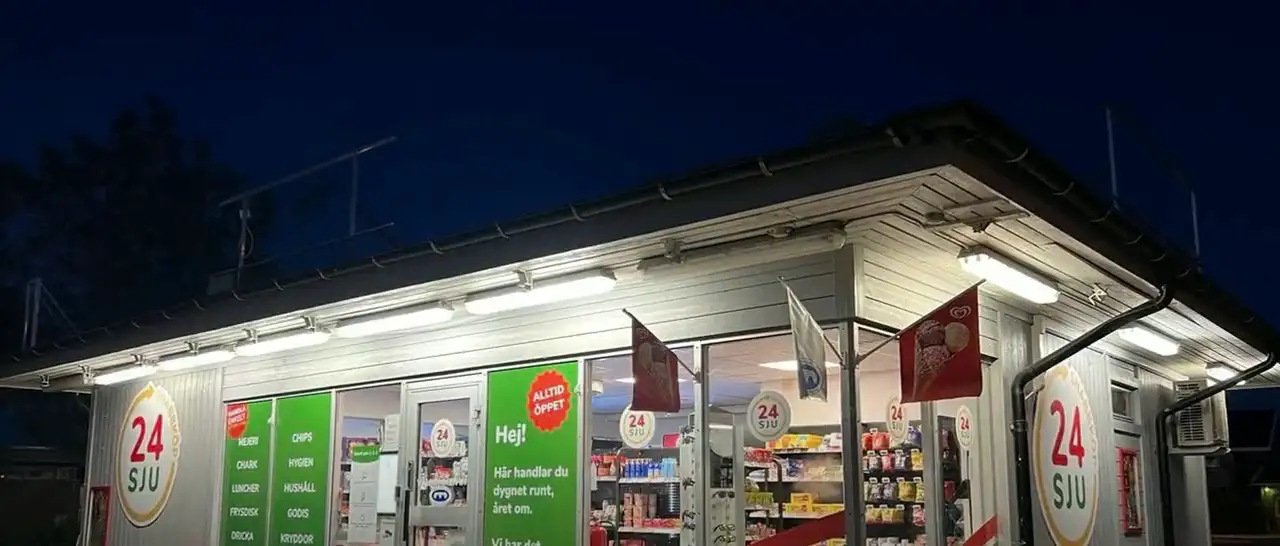 A 24SJU smart store lit up at night